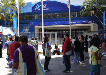 Imagem ilustrativa de participantes reunidos na entrada de um local de aplicação de provas, cena que remete ao acesso ao local no dia do Encceja 2026