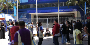 Imagem ilustrativa de participantes reunidos na entrada de um local de aplicação de provas, cena que remete ao acesso ao local no dia do Encceja 2026