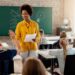 MEC encerra nesta sexta (21) consulta sobre formação continuada de professores 11 Imagem ilustrativa de professora conduzindo aula em sala com estudantes sentados e um deles com a mão levantada, em referência à consulta do MEC sobre formação continuada de professores