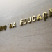 Fachada do prédio do Ministério da Educação, com o nome do órgão em letras douradas aplicadas sobre parede de revestimento claro, vista em ângulo de baixo para cima.