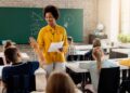 Imagem ilustrativa de docente à frente da lousa interagindo com alunos durante a aula, em referência às vagas de mestrado abertas pela parceria entre MEC e Capes para professores da rede pública