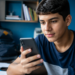 Estudantes do Enem ganham app do MEC com simulados e correção de redação por IA em até 60 segundos 11 Estudante brasileiro usando smartphone durante preparação para o Enem em ambiente de estudos.