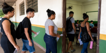 Estudantes entrando em sala de aula para realizar a prova do Encceja 2026 em escola pública.