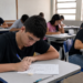 Jovens realizando a prova do Encceja 2026 em sala de aula de escola pública.