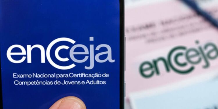 Como solicitar a reaplicação do Encceja 2026 Imagem ilustrativa da marca do Encceja exibida na tela de um celular ao lado de cartões-resposta do exame, em referência ao pedido de reaplicação da prova