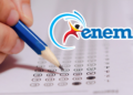 Mão segura lápis azul preenchendo folha de respostas do ENEM com logo do exame em destaque.