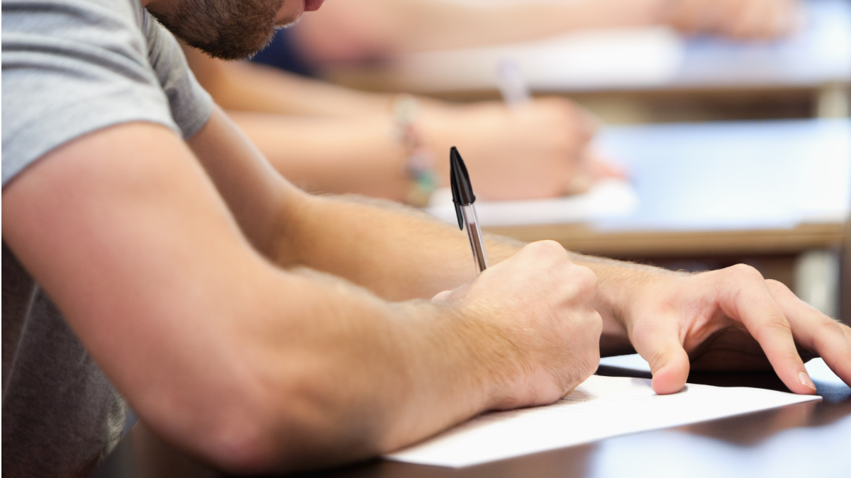 Horários PND. Jovem fazendo prova em sala de aula.