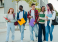 Grupo diverso de estudantes universitários caminhando juntos no campus moderno.