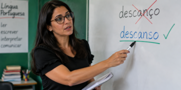 Professora corrigindo no quadro branco as palavras “descanço” e “descanso”, destacando a grafia correta da palavra.