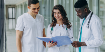 Estudantes de medicina analisam documentos em hospital durante preparação para o Enamed 2026.