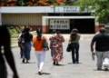 Candidatos caminham em direção ao local de prova da Prova Nacional Docente (PND) representando a aplicação do exame.