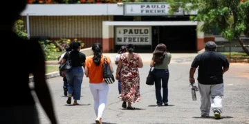 Candidatos caminham em direção ao local de prova da Prova Nacional Docente (PND) representando a aplicação do exame.