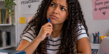 Estudante com expressão de dúvida durante estudo de português sobre o uso correto de pode vir e pode vim.