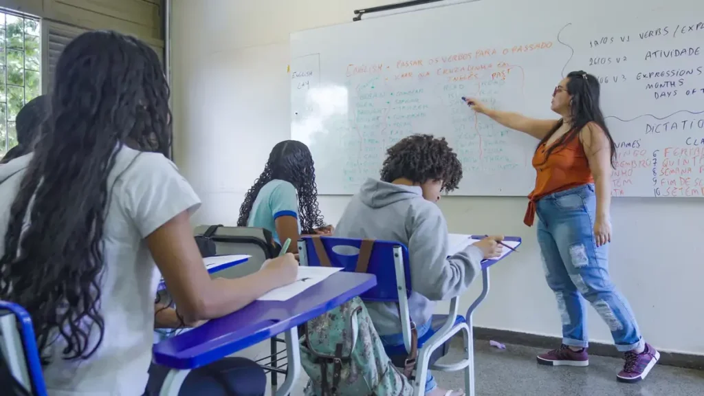 PND: mais de 10 mil professores foram selecionados no último ano em editais que utilizaram a nota do exame 1 Professora ministra aula para estudantes em sala, representando seleção de docentes por meio da nota da Prova Nacional Docente (PND).