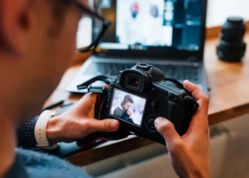 Fotografia e edição de vídeo: trilha online reúne 3 cursos e oferece 240 horas de aprendizado 5 Pessoa utilizando câmera fotográfica profissional para revisar imagens, representando os cursos online de fotografia e edição de vídeo.