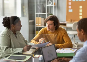 Supervisão Pedagógica: curso online de 80 horas ensina como atuar na gestão educacional 5 Profissionais reunidos em ambiente escolar analisam documentos e discutem estratégias de gestão e supervisão pedagógica.
