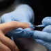Do soft gel à fibra de vidro: curso reúne 39 conteúdos sobre alongamento de unhas 12 Profissional aplica esmalte azul em unha durante procedimento de alongamento e cuidados de manicure.