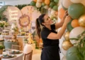 Decoração de festas infantis pode virar fonte de renda; conheça o curso que ensina a atuar na área 11 Mulher trabalha na decoração de uma festa infantil, organizando balões modernos em um ambiente com tema de safari, mesa de doces e elementos decorativos.