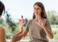 Libras além do básico: curso online ajuda a desenvolver habilidades avançadas de comunicação 2 Mulher utilizando a Língua Brasileira de Sinais (Libras) durante uma conversa, representando o desenvolvimento de habilidades avançadas de comunicação.