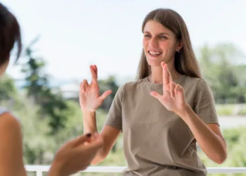 Libras além do básico: curso online ajuda a desenvolver habilidades avançadas de comunicação 5 Mulher utilizando a Língua Brasileira de Sinais (Libras) durante uma conversa, representando o desenvolvimento de habilidades avançadas de comunicação.