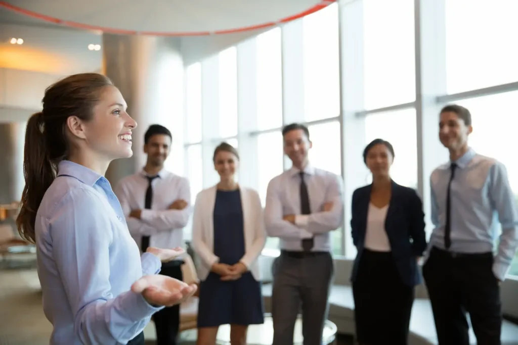 Profissional apresenta estratégias de liderança e gestão de equipes durante reunião com colegas em ambiente corporativo.