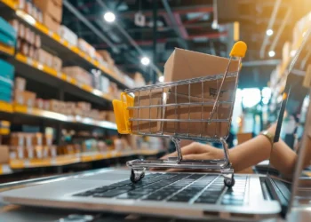 Curso online de atendimento e vendas no varejo aposta em técnicas para conquistar e fidelizar clientes 5 Carrinho de compras sobre notebook em ambiente de varejo representa curso online da Bizu sobre atendimento, vendas e fidelização de clientes.